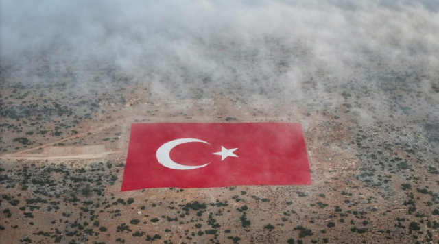 Van Çaldıran'in Mut ilçesinde bulunan ve yaklaşık 22 dönümlük dev bir arazi üzerine titizlikle işlenen Türk bayrağı, sabah saatlerinde etkili olan yoğun sis ile birlikte adeta masalsı bir manzara sundu.